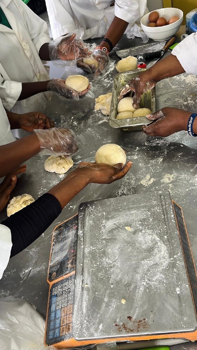Hands portioning and shaping dough into rolls